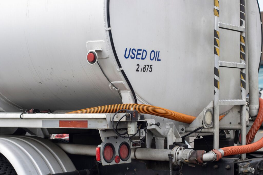 A white truck with hoses attached to it.